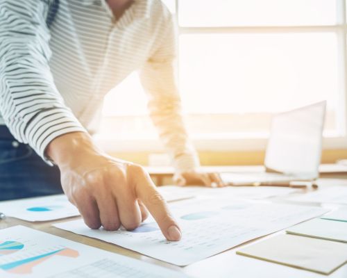 Businessman pointing to financial chart, doing finances and calculate about cost