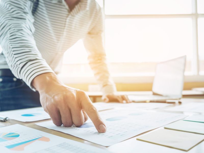 Businessman pointing to financial chart, doing finances and calculate about cost